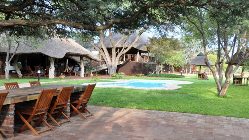 Utomhusområdet med matplats och swimmingpool på Temba Safari Lodge i Sydafrika.